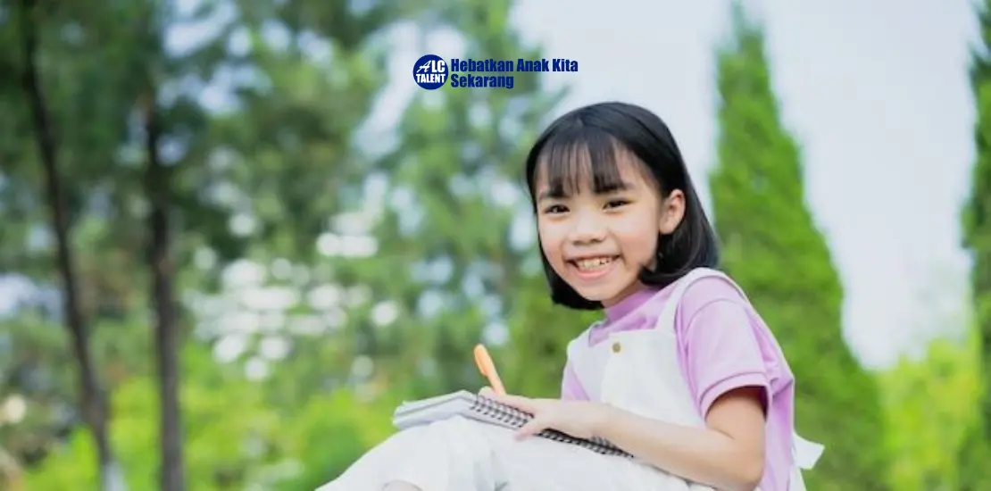 seorang anak perempuan sedang tersenyum dan memegang buku catatan dan pena